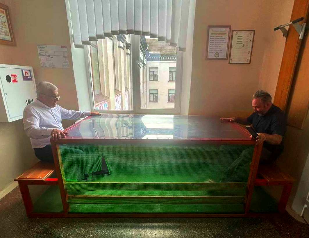 О.Остапчук  разом з магістрантом В.Білінчуком демонструють, як учні грають у футбол сидячи